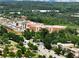 Scenic aerial view of a brick building with ample parking, surrounded by trees and a clear roadway at 4905 Sterling Close, Buford, GA 30518