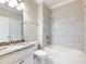 Bathroom with a white tub, tile surround, granite countertop and white vanity at 4905 Sterling Close, Buford, GA 30518