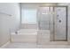 Bathroom featuring a soaking tub and a glass enclosed shower with tile surround and flooring at 4905 Sterling Close, Buford, GA 30518