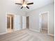 Large bedroom featuring three doorways with modern carpeting and ceiling fan at 4905 Sterling Close, Buford, GA 30518