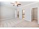 Large carpeted bedroom with ceiling fan, and adjoining bath and walk in closet at 4905 Sterling Close, Buford, GA 30518