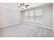 Spacious bedroom with soft carpet, ceiling fan, and three large windows at 4905 Sterling Close, Buford, GA 30518