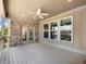 Covered deck with a ceiling fan, a brick accent wall, and a view of the backyard at 4905 Sterling Close, Buford, GA 30518