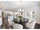 Open dining area with chandelier, hardwood floors, and views into a modern kitchen at 4905 Sterling Close, Buford, GA 30518
