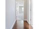 Hallway with hardwood floors leading to a carpeted bedroom and a glimpse of natural light at 4905 Sterling Close, Buford, GA 30518
