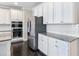 Modern kitchen featuring white cabinets, stainless steel appliances, granite countertops, and subway tile backsplash at 4905 Sterling Close, Buford, GA 30518