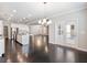 Open-concept living room flowing from a kitchen with hardwood floors and a chandelier lighting up the space at 4905 Sterling Close, Buford, GA 30518