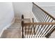 Carpeted stairs with dark wood railing and iron spindles, offering a stylish transition between floors at 4905 Sterling Close, Buford, GA 30518