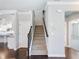 Carpeted staircase with wooden railing providing access to the upper and lower levels of the home at 4905 Sterling Close, Buford, GA 30518
