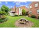 Stone table and benches in manicured back yard of townhome with green lawns and garden beds at 505 Ansley Villa Dr, Atlanta, GA 30324