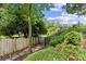 This backyard features manicured landscaping, a secure iron fence, and a stone walkway to access the outdoor space at 505 Ansley Villa Dr, Atlanta, GA 30324