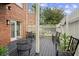Back patio with dark wood flooring, metal table and chairs and white picket fence at 505 Ansley Villa Dr, Atlanta, GA 30324