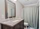 Bathroom featuring vanity with granite countertop, decorative mirror and combination shower and tub at 505 Ansley Villa Dr, Atlanta, GA 30324