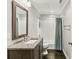 A stunning bathroom with a vanity, decorative framed mirror, combination shower and tub, and white subway tile at 505 Ansley Villa Dr, Atlanta, GA 30324