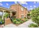 Brick townhome with covered porch, landscaped garden, and brick steps at 505 Ansley Villa Dr, Atlanta, GA 30324