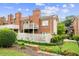 Exterior view of red brick townhomes surrounded by green lawns, plants, and gardens at 505 Ansley Villa Dr, Atlanta, GA 30324
