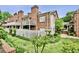 Exterior view of townhomes showing garden beds, brick facades, and private decks at 505 Ansley Villa Dr, Atlanta, GA 30324