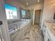 Bright bathroom with marble tile, soaking tub, glass shower, and double sinks at 508 Healy Dr # 70, Cumming, GA 30040