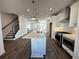 Modern kitchen with island, stainless steel appliances, open to living space, and adjacent to the staircase at 508 Healy Dr # 70, Cumming, GA 30040