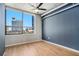 Inviting bedroom featuring hardwood floors and a large window with cityscape view at 115 W Peachtree Nw Pl # 713, Atlanta, GA 30313
