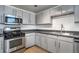 Modern kitchen with stainless steel appliances, gray cabinets, and stylish backsplash at 115 W Peachtree Nw Pl # 713, Atlanta, GA 30313