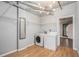 Well-lit laundry room with washer, dryer, storage racks, and modern lighting fixture at 115 W Peachtree Nw Pl # 713, Atlanta, GA 30313