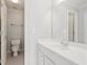 Bright bathroom featuring white vanity, large mirror, and toilet at 11945 Dancliff Trce, Alpharetta, GA 30009