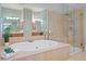 Luxurious bathroom with a soaking tub, glass shower, and double vanities at 11945 Dancliff Trce, Alpharetta, GA 30009