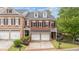 Beautiful brick townhome featuring a two-car garage, manicured landscaping, and a classic architectural design at 11945 Dancliff Trce, Alpharetta, GA 30009
