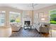 Living room with fireplace, plush seating, hardwood floors and bright windows allowing plenty of natural light at 11945 Dancliff Trce, Alpharetta, GA 30009