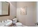 Stylish powder room features a decorative mirror, elegant fixtures, and neutral paint, creating a welcoming space at 11945 Dancliff Trce, Alpharetta, GA 30009