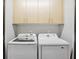 Convenient laundry room with side-by-side washer and dryer and upper cabinets at 1323 Peachtree Ne Vw, Atlanta, GA 30319
