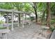 Outdoor stone patio featuring pergola, decorative pea gravel and two round tables with seating at 1323 Peachtree Ne Vw, Atlanta, GA 30319