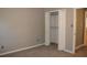 A bedroom with gray colored walls, beige carpeting and an opened closet at 2031 Lakewood Cir, Grayson, GA 30017