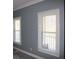 A bedroom featuring two windows, white window trim, and gray colored walls at 2031 Lakewood Cir, Grayson, GA 30017