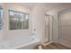 Bathroom featuring a soaking tub under a large window and a separate glass-enclosed shower at 7 Camellia Dr, Fairburn, GA 30213