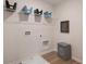 Functional laundry room featuring overhead storage baskets and wood-look flooring at 7 Camellia Dr, Fairburn, GA 30213