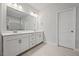 Bathroom features double sink vanity with white countertops and cabinets and a large mirror at 730 Lanarck Way, Peachtree City, GA 30269