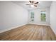 Bright bedroom with hardwood floors and dual windows overlooking a beautiful green view at 730 Lanarck Way, Peachtree City, GA 30269