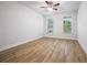 Bright, airy bedroom featuring neutral walls, wood flooring, and ample natural light from two windows at 730 Lanarck Way, Peachtree City, GA 30269