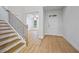 Inviting entryway with hardwood floors, a staircase with dark railings, and a view into a living area at 730 Lanarck Way, Peachtree City, GA 30269