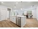 Kitchen island with stainless steel dishwasher and sink opens to the dining room in this bright new home at 730 Lanarck Way, Peachtree City, GA 30269
