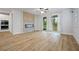 Open-concept living room with hardwood floors, brick fireplace, and sliding glass doors to yard at 730 Lanarck Way, Peachtree City, GA 30269