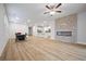 Expansive living room with a fireplace, hardwood floors, and views into the kitchen and dining areas at 730 Lanarck Way, Peachtree City, GA 30269