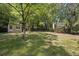 Large backyard featuring mature trees, a storage shed, and a fenced perimeter at 1111 Louise Se Ct, Conyers, GA 30013