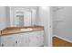 Bathroom vanity area with white cabinets, a cream countertop, and a large mirror at 1111 Louise Se Ct, Conyers, GA 30013