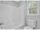 Bright bathroom features a tub and shower combination, a window, and neutral paint at 1111 Louise Se Ct, Conyers, GA 30013