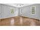Bright bedroom features laminate wood floors, neutral walls, and natural light from windows at 1111 Louise Se Ct, Conyers, GA 30013