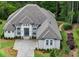 An aerial view of a pristine brick home, surrounded by lush greenery and manicured landscaping at 4216 Tattnall Run, Acworth, GA 30101