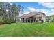 Expansive backyard featuring a covered patio, lush lawn, and a fence line surrounded by mature trees at 4216 Tattnall Run, Acworth, GA 30101